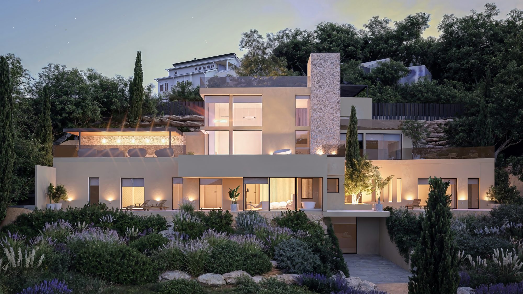 Fachada iluminada al atardecer de la villa en Roca Llisa, Ibiza